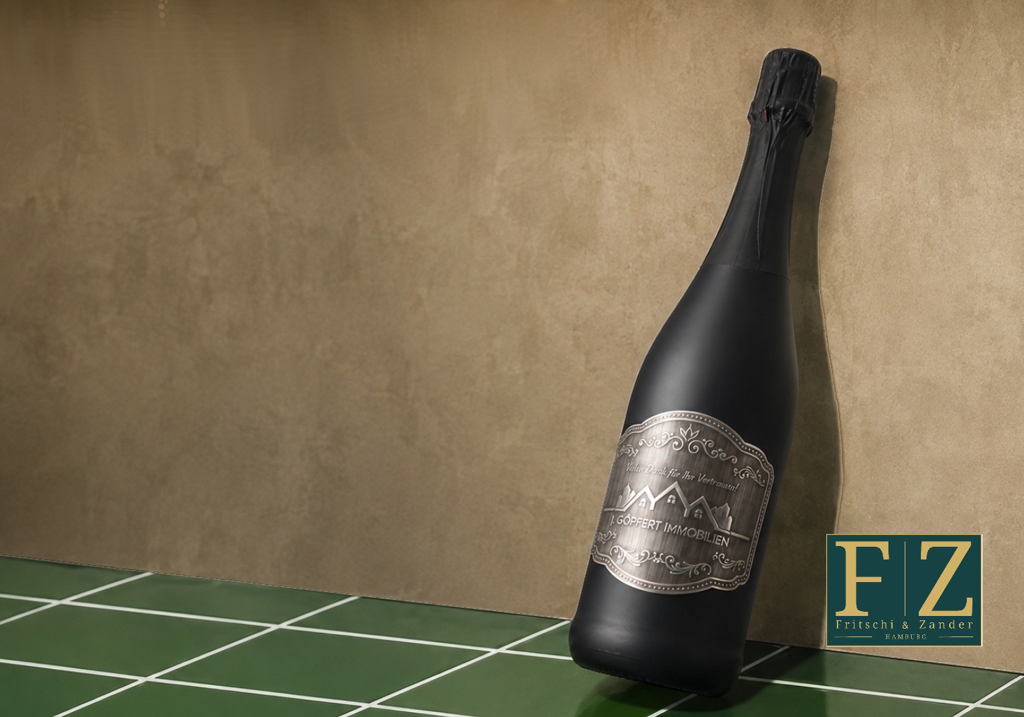 Schwarze Sektflasche mit metallveredeltem Etikett an einer Lehmwand